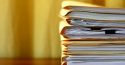 Manila file folders stacked on a desk.